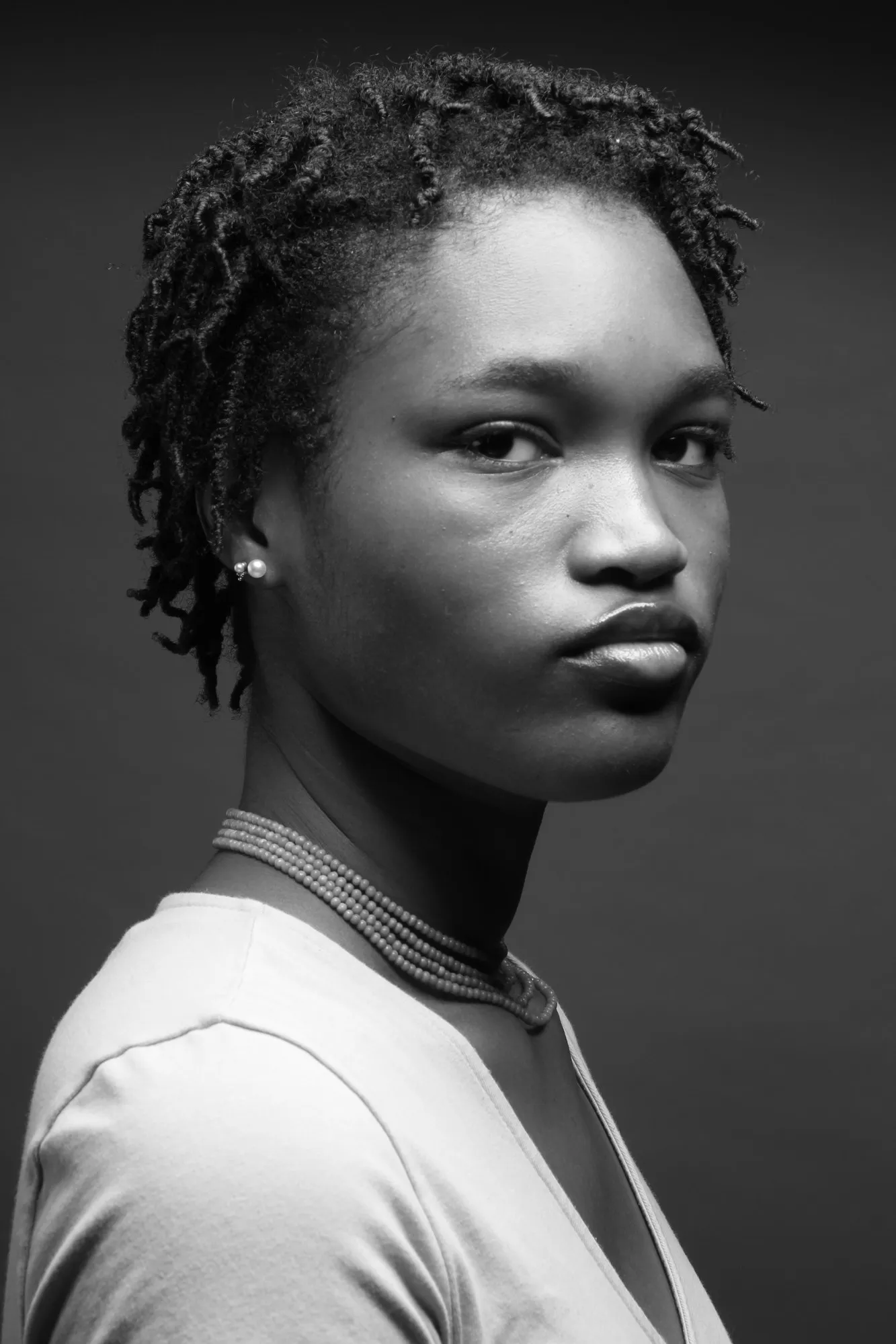 A black-and-white studio portrait of Adeoti.