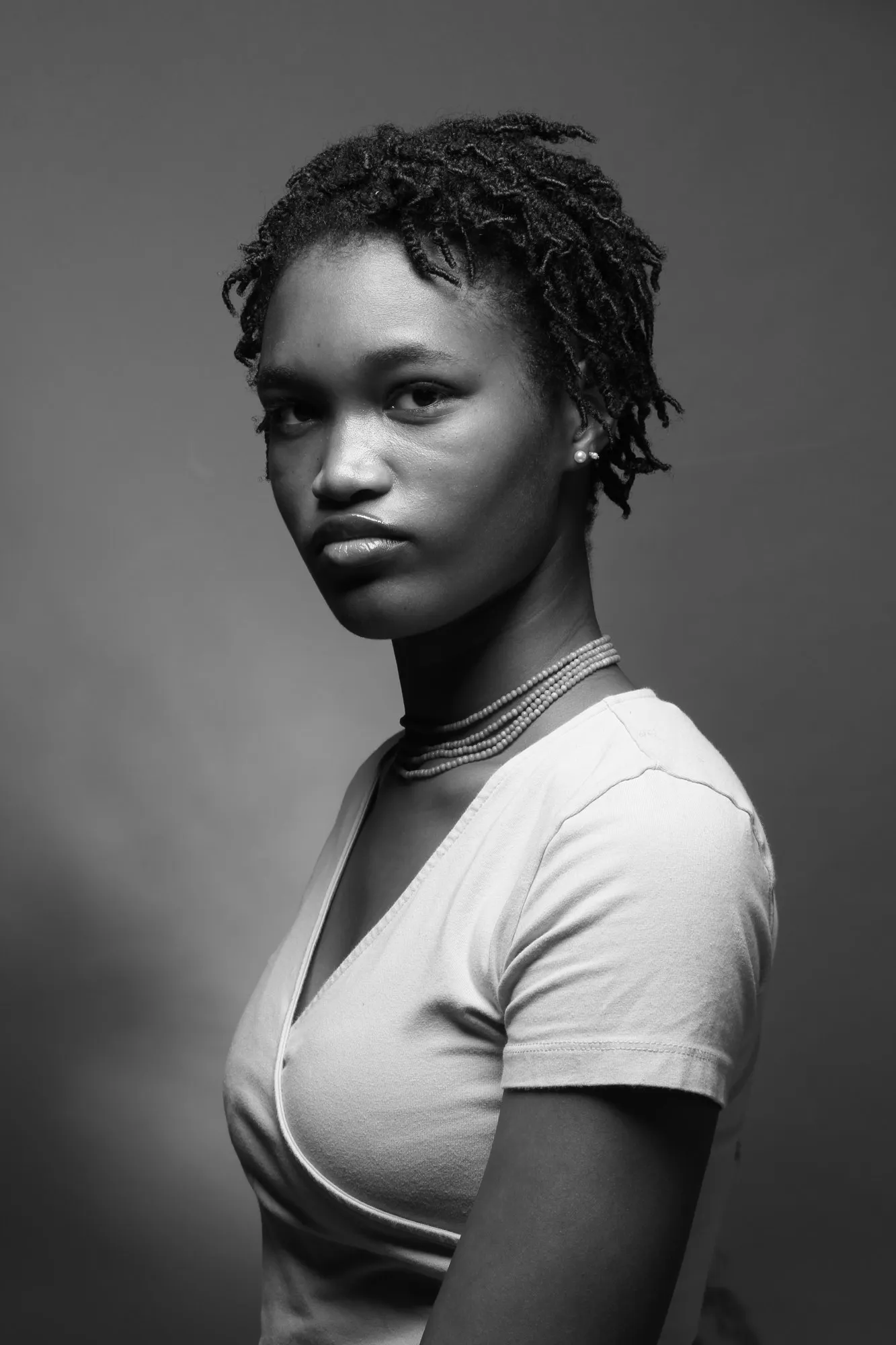 A studio portrait of Adeoti against a dark background.