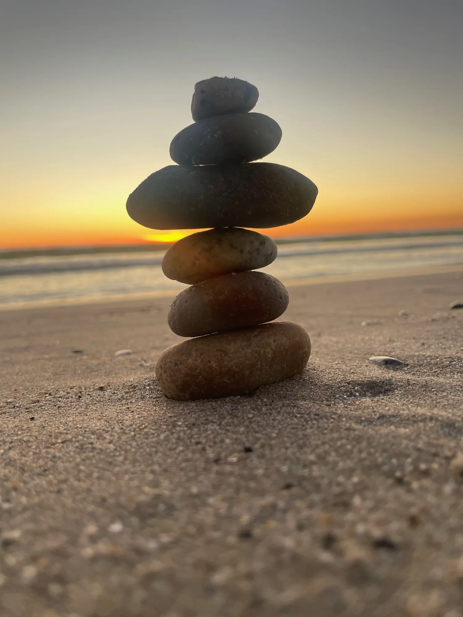 Balanced stones at the water’s edge. A beach observation made in the changing evening light.