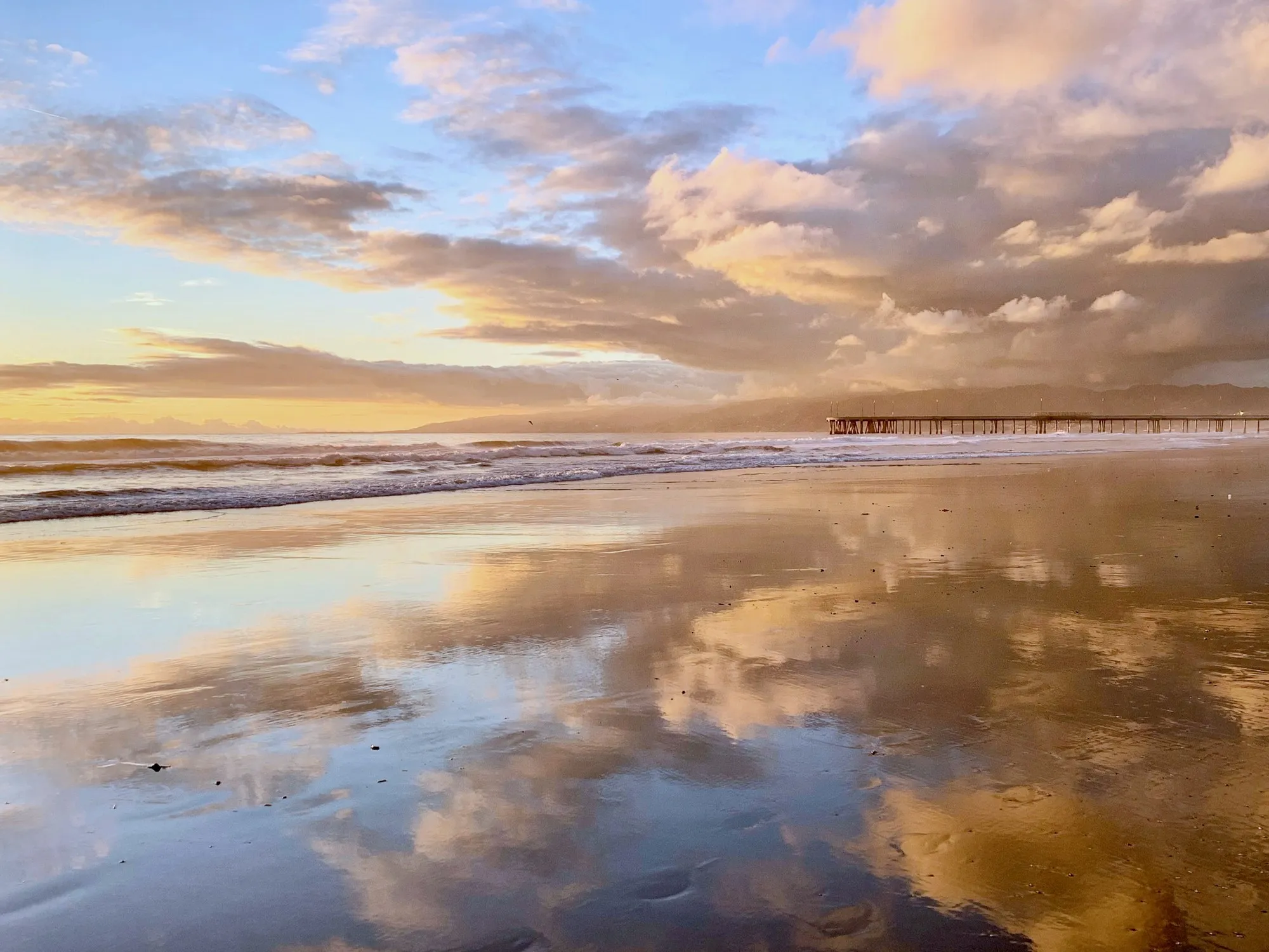Clouds reflected across the shoreline. A beach observation made in the changing evening light.
