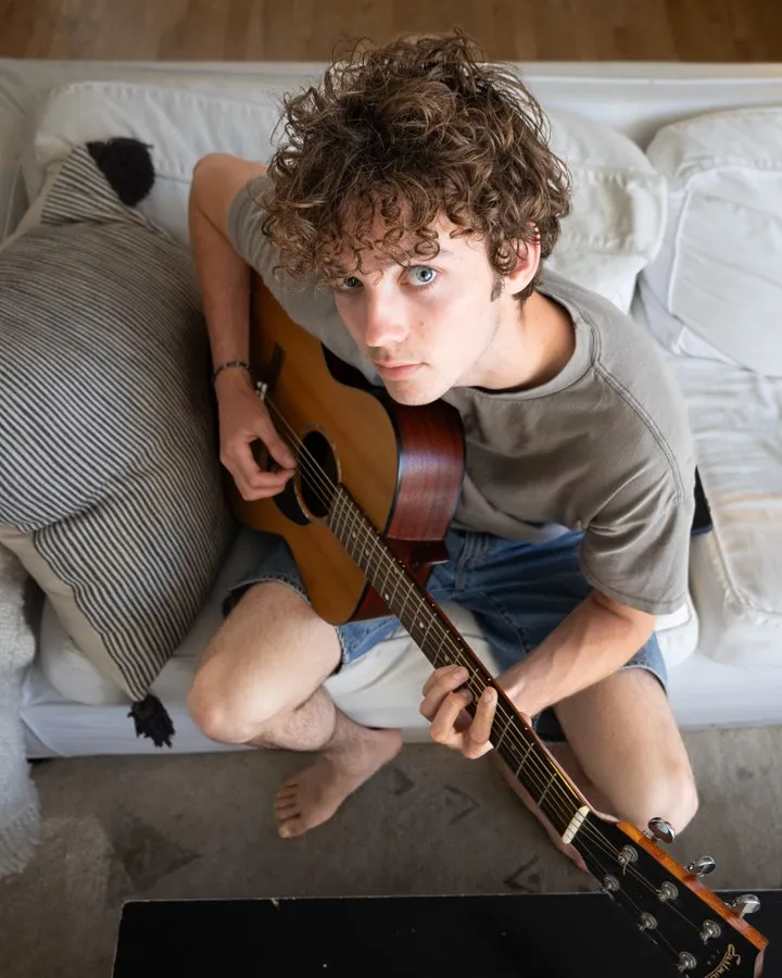 Oliver sits with a guitar.