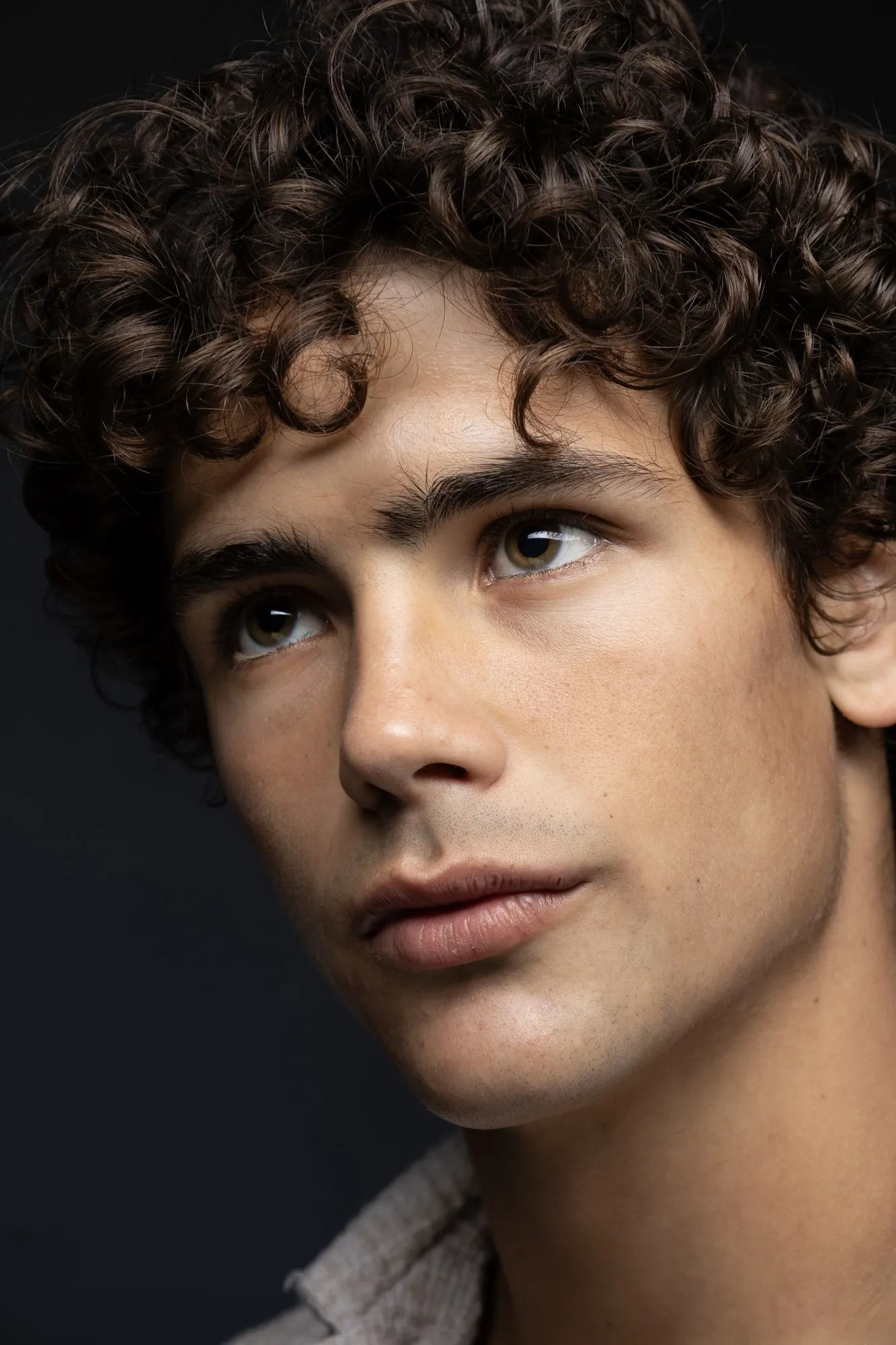 Close portrait of a curly-haired man looking to the side