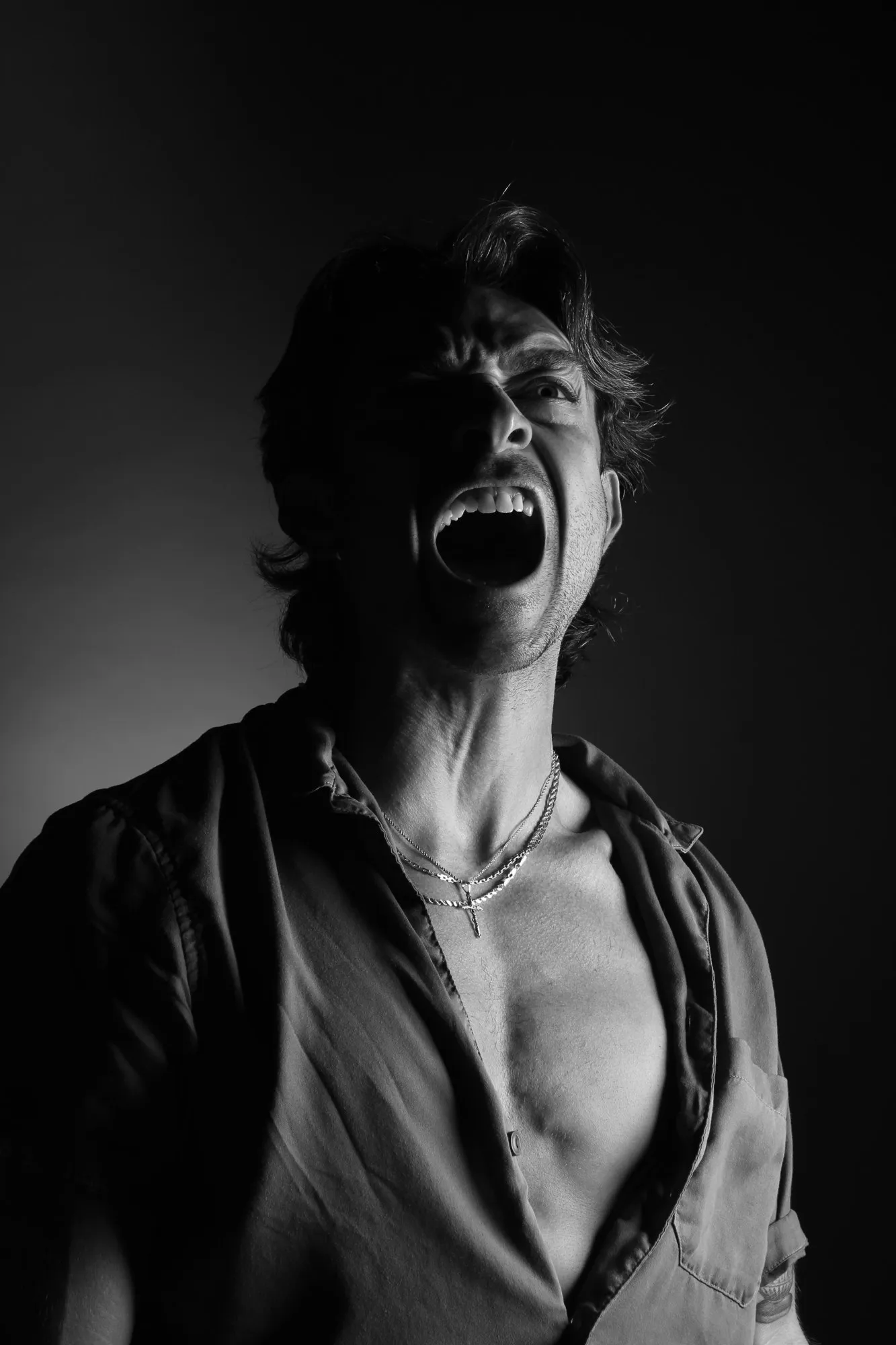 A face emerging from darkness with the head tilted back