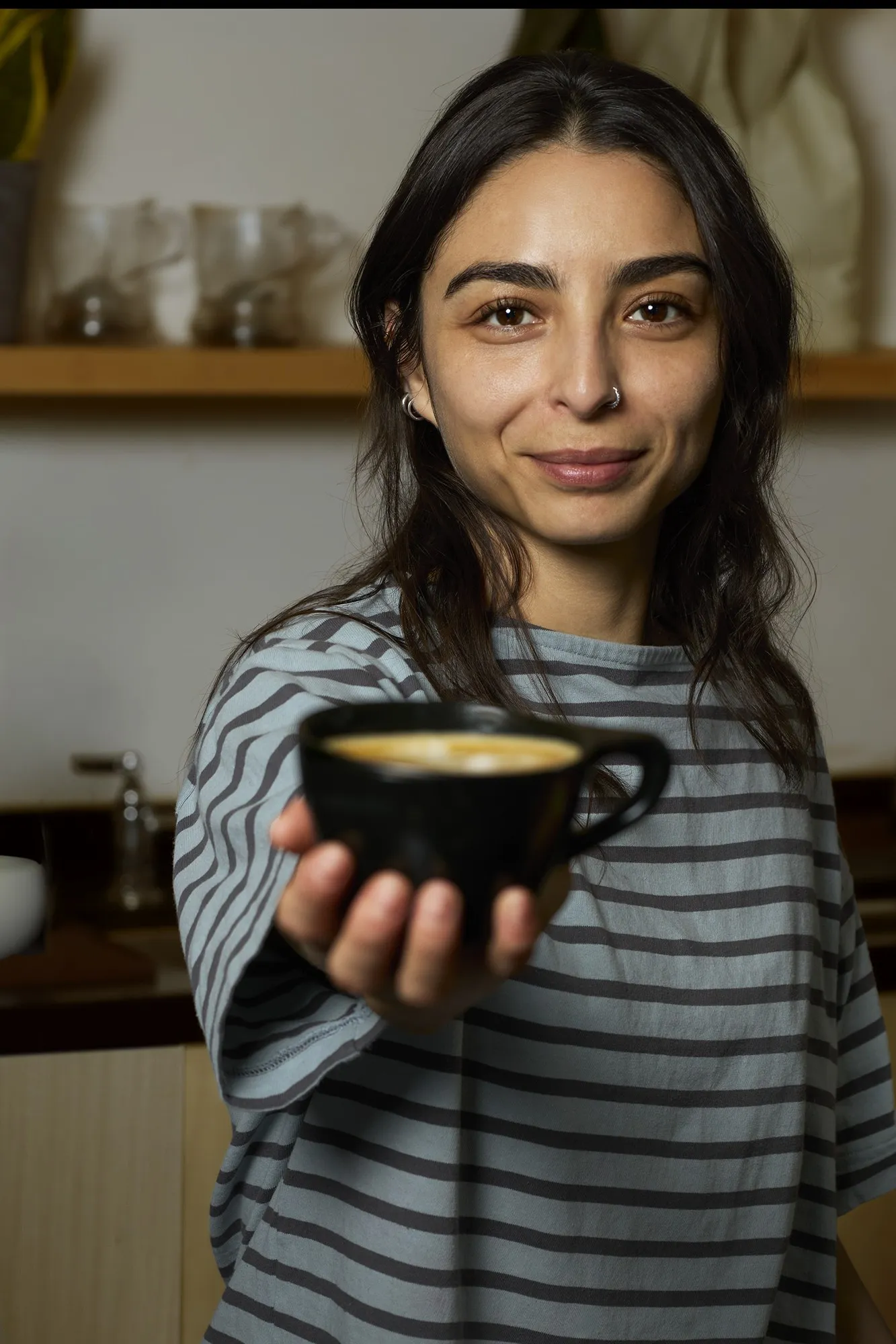 A woman offering a small bowl toward the camera
