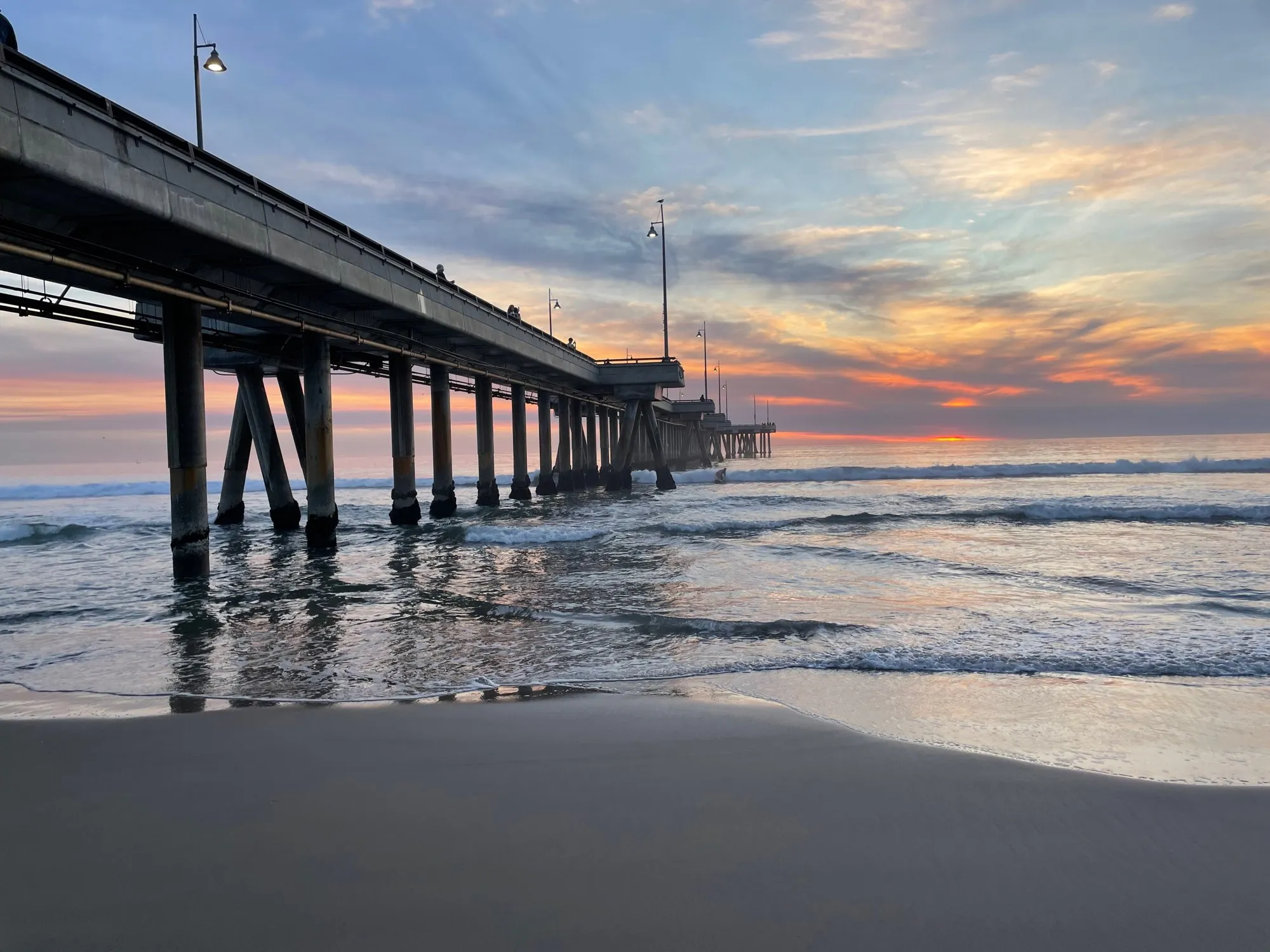 Pier and waves at golden hour. A beach observation made in the changing evening light.