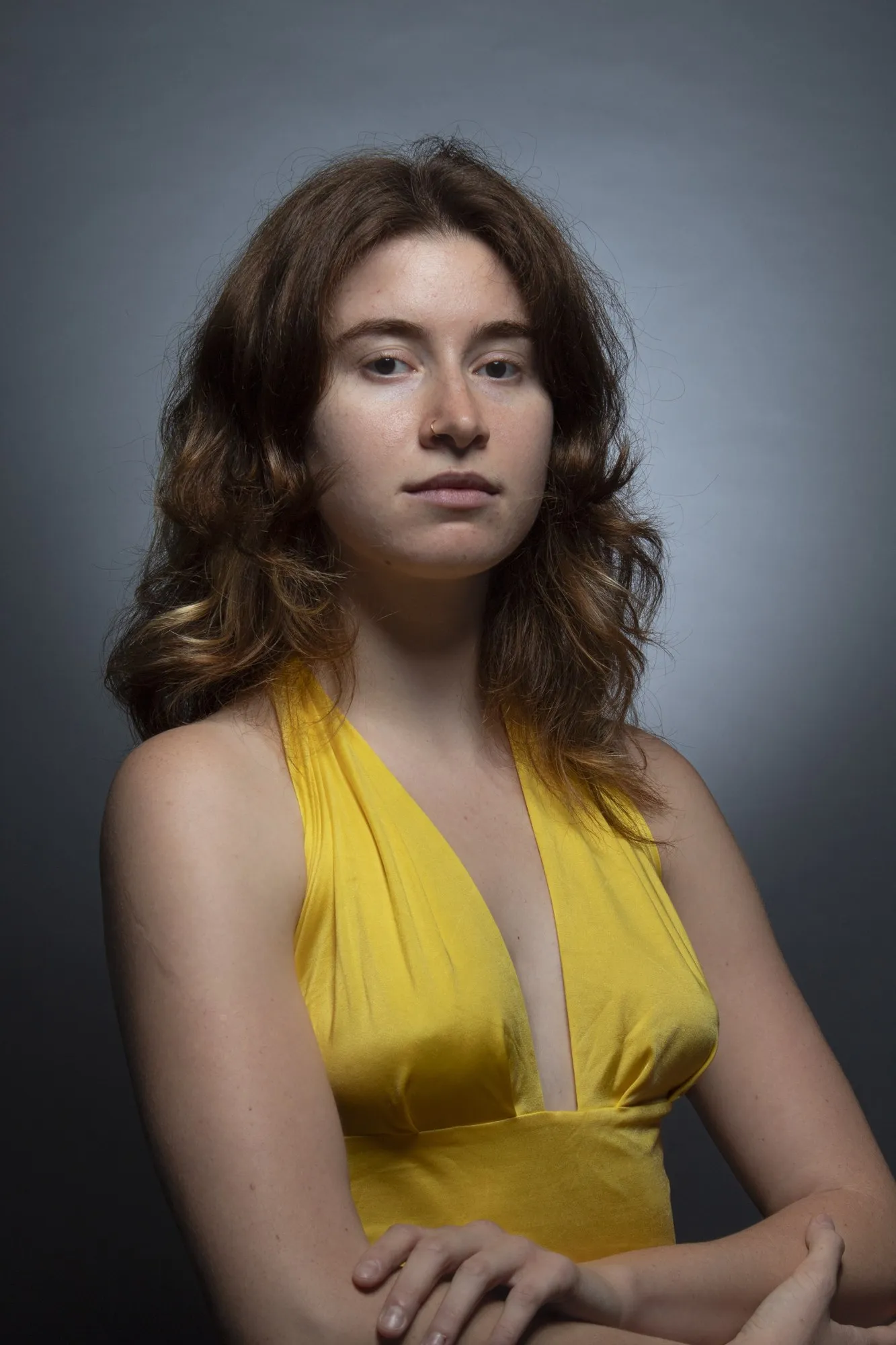 A young woman in a yellow top looks toward the camera.