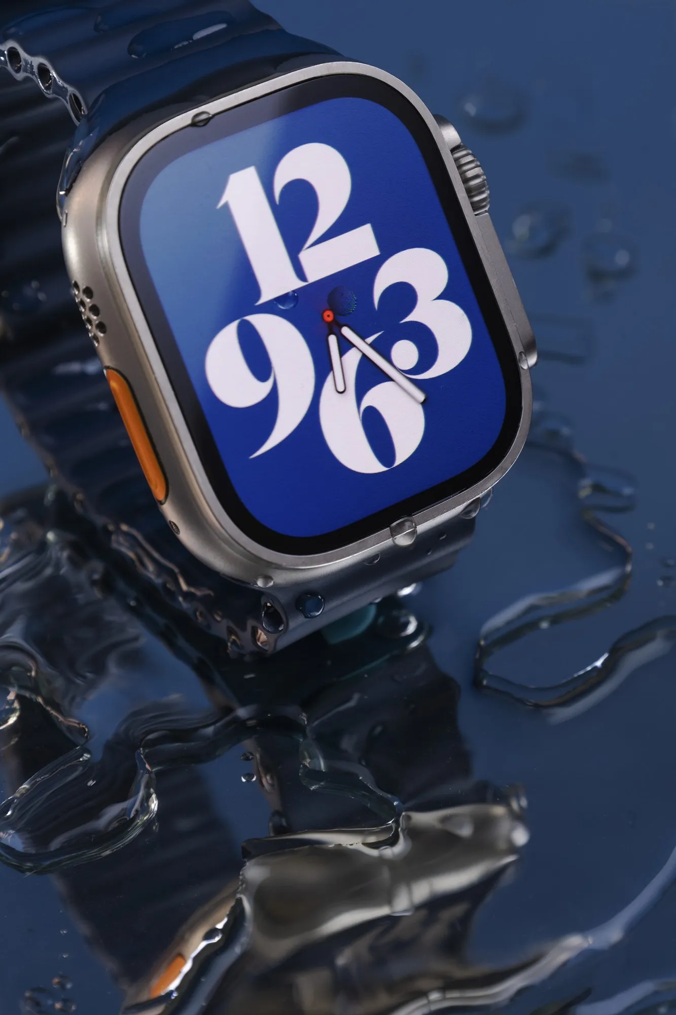 A blue-faced watch surrounded by reflective dark water