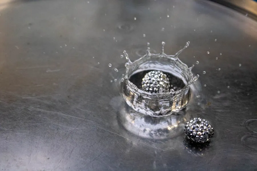A splash of water surrounding metallic textured spheres