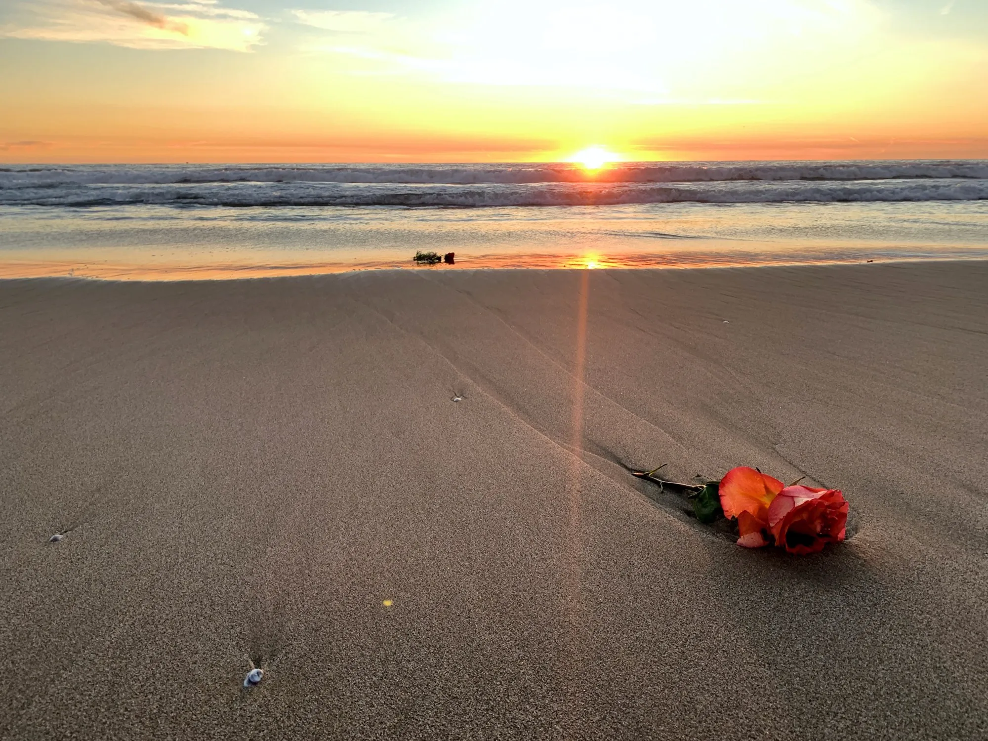 A red toy on the sand at sunset. A beach observation made in the changing evening light.