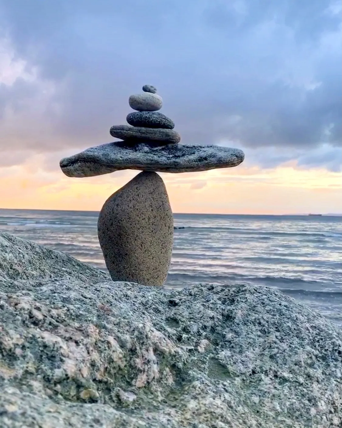 A small balanced stone sculpture with a long flat stone across its top