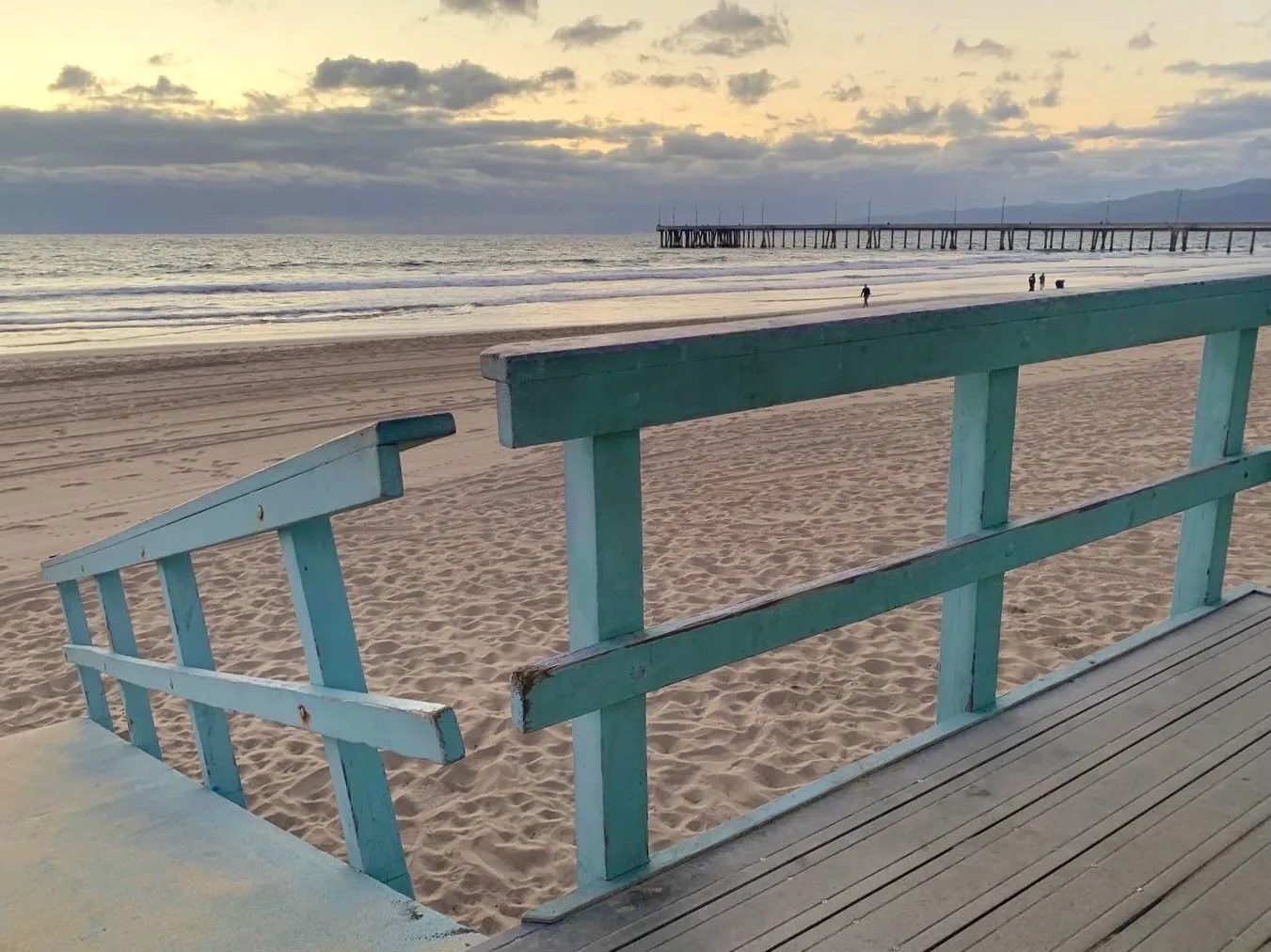 A seaside railing in the afternoon light. A beach observation made in the changing evening light.