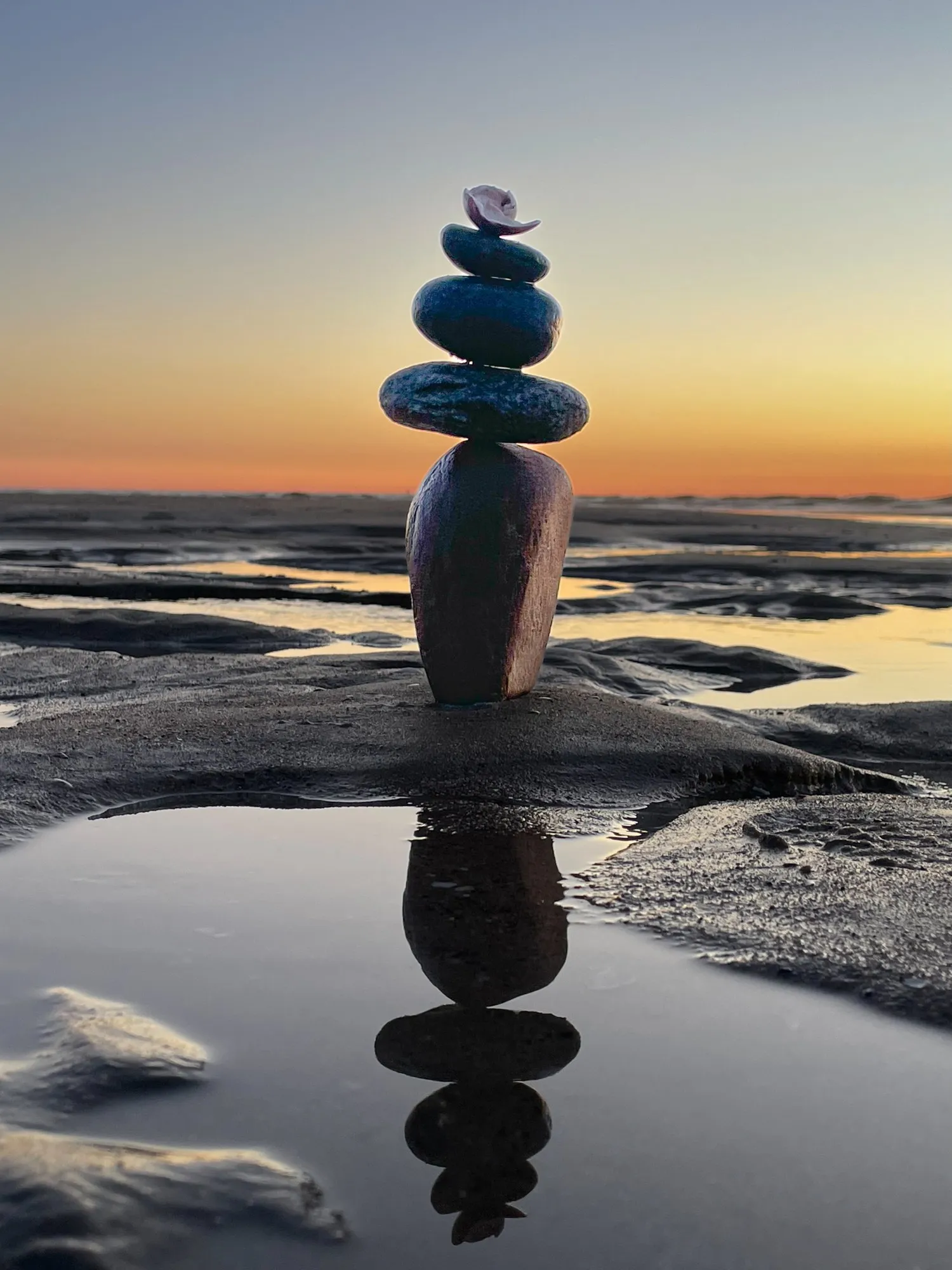 A small stone tower stands in silhouette against a glowing evening sky.
