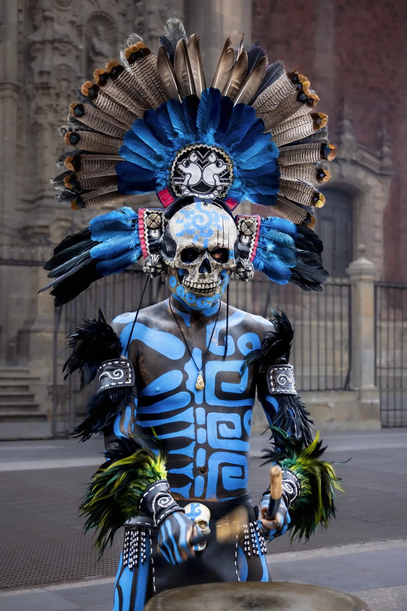 A costumed figure stands in a Mexico City doorway.
